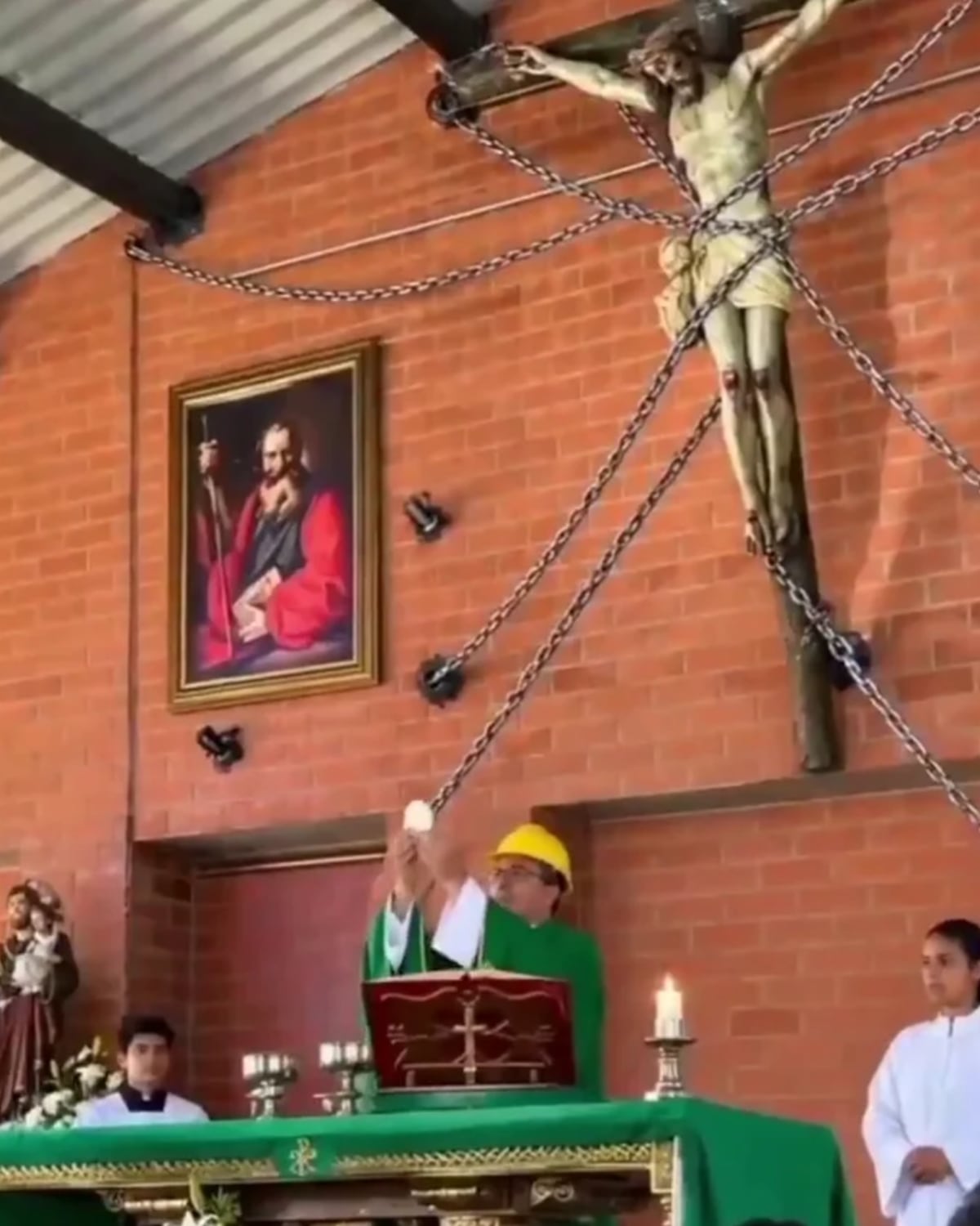 Vídeo Viral | Para que no se caiga: sacerdote celebra misa con casco y aseguran a Cristo con cadenas